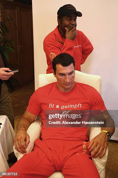 Wladimir Klitschko of Ukraine and his coach Emanuel Steward look glum during a press conference as they discover the fight with heavyweight rival...
