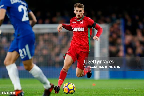 Swansea City's English midfielder Tom Carroll runs with the ball during the English Premier League football match between Chelsea and Swansea City at...