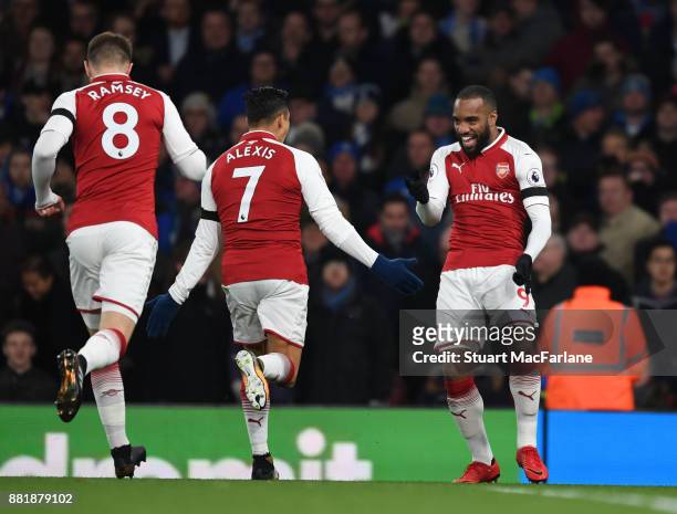 Alex Lacazette celebrates scoring for Arsenal with Alexis Sanchez and Aaron Ramsey during the Premier League match between Arsenal and Huddersfield...