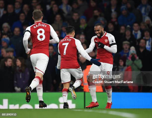 Alex Lacazette celebrates scoring for Arsenal with Alexis Sanchez and Aaron Ramsey during the Premier League match between Arsenal and Huddersfield...