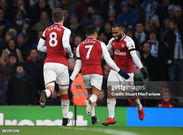 Alex Lacazette celebrates scoring for Arsenal with Alexis Sanchez and Aaron Ramsey during the Premier League match between Arsenal and Huddersfield...