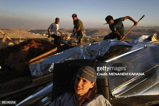 Jewish settler takes a break as others rebuild the destroyed Migron outpost in the occupied West Bank on June 3, 2009. Israeli security forces...