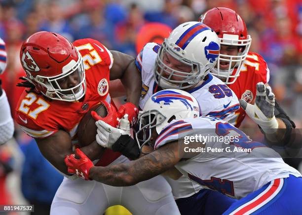 Defenders Leonard Johnson and Kyle Williams of the Buffalo Bills tackle running back Kareem Hunt of the Kansas City Chiefs during the first half at...