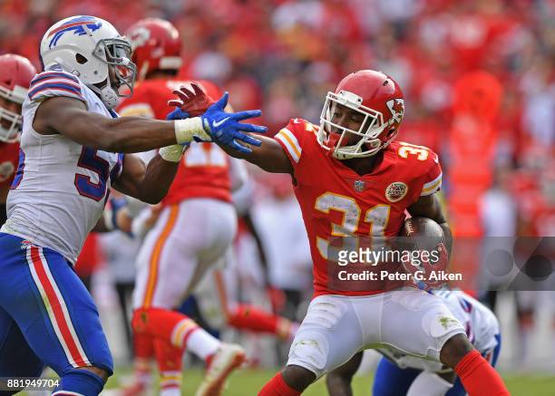 Running back Akeem Hunt of the Kansas City Chiefs attempts to brake away from defensive end Jerry Hughes of the Buffalo Bills during the second half...