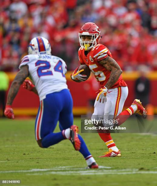 Running back Charcandrick West of the Kansas City Chiefs runs up field against defensive back Leonard Johnson of the Buffalo Bills during the second...