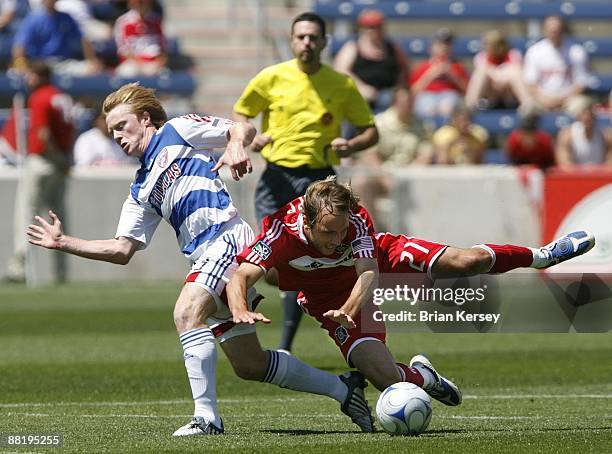 Justin Mapp of the Chicago Fire falls as he and Dax McCarty of FC Dallas chase after the ball during the first half at Toyota Park on May 31, 2009 in...