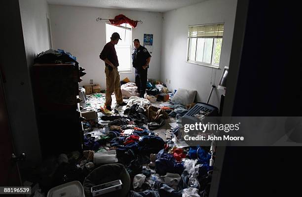 Sheriff's Deputy Rick Ferguson supervises as an eviction team leader inspects belongings left behind in a house foreclosed upon June 3, 2009 in...