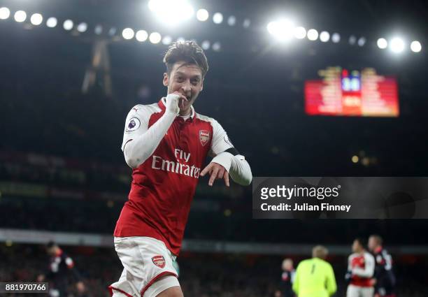 Mesut Ozil of Arsenal celebrates after scoring his sides fourth goal during the Premier League match between Arsenal and Huddersfield Town at...