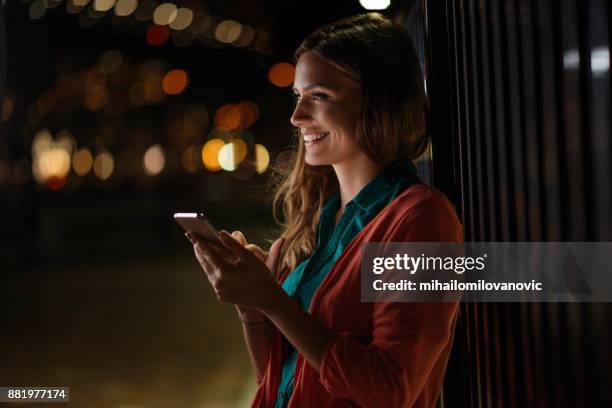 happy woman using phone - australia city night stock pictures, royalty-free photos & images