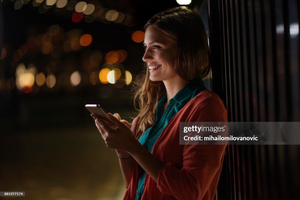 Mulher feliz usando o telefone