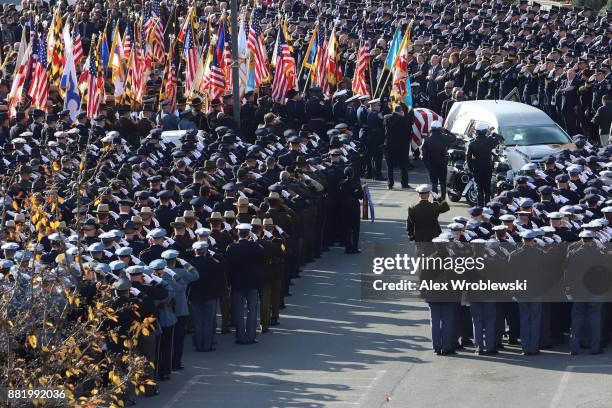 Mourners salute as the hearse carrying the remains of Detective Sean Suiter passes by on November 29, 2017 in Baltimore, Maryland. Suiter, a...