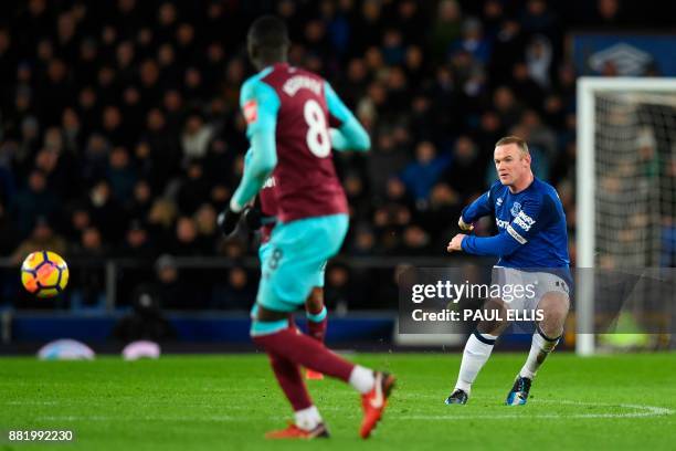 Everton's English striker Wayne Rooney shoots from the half-way line to score his third goal to complete his hattrick during the English Premier...