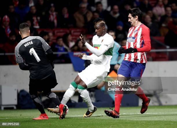 Stefan Savic and Miguel Angel Moya of Atletico Madrid in action against Sory Kaba of Elche during the King's Cup soccer match between Atletico Madrid...