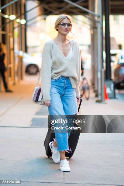 Martha Hunt is seen wearing a Khaite sweater, RE/Done jeans, Treyton shoes with a Byredo hangbag and vintage sunglasses in Chelsea on November 29,...