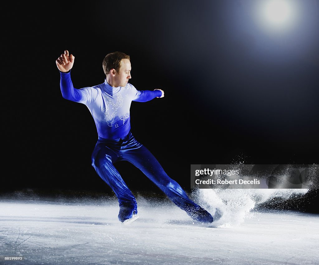 Figure skater creating spray of ice.