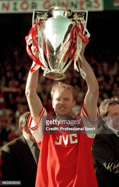 Dennis Bergkamp of Arsenal lifts the FA Carling Premiership trophy after the final home game of the season against Everton at Highbury on May 03,...