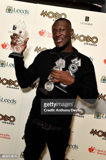 Stormzy poses in the winners room with the awards for Best Male, Best Grime and Best Album at the MOBO Awards at First Direct Arena Leeds on November...