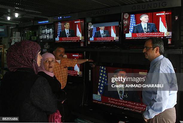 Palestinains listen to US President Barack Obama's speech at Cairo University, at an electronics shop in Arab east Jerusalem on June 4, 2009....