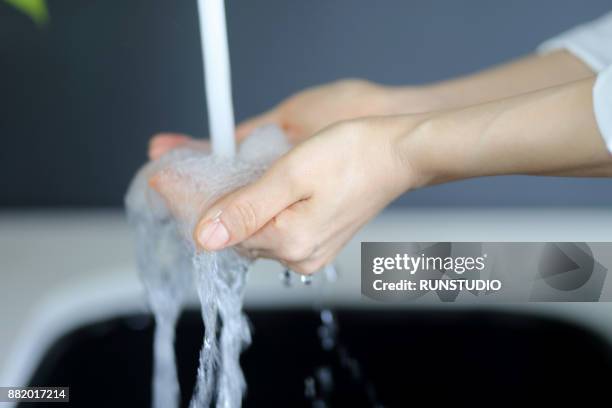 woman washing hands in washstand - faucet imagens e fotografias de stock