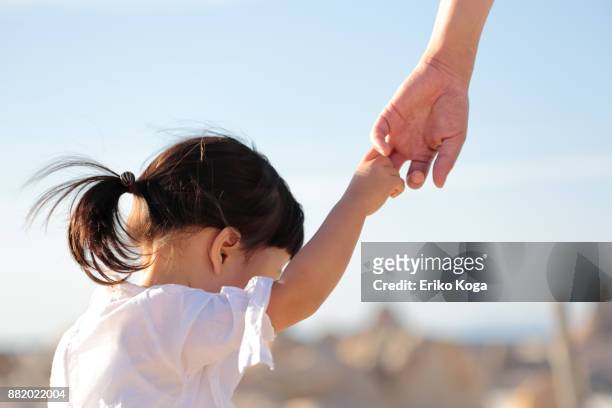 father and daughter walking hand in hand on beach - child hand stock pictures, royalty-free photos & images