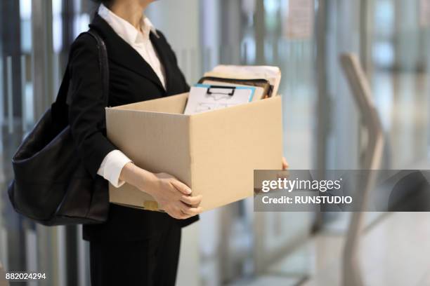 businesswoman leaving office with box of personal items - afwijzing stockfoto's en -beelden