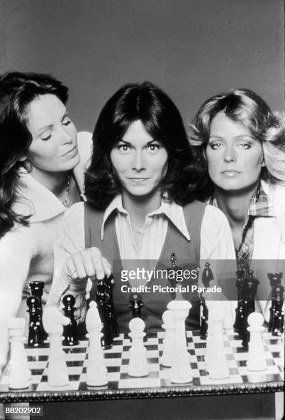 Promotional portrait of, from left, American actresses Jaclyn Smith, Kate Jackson, and Farrah Fawcett as they pose behind a chess board for the...