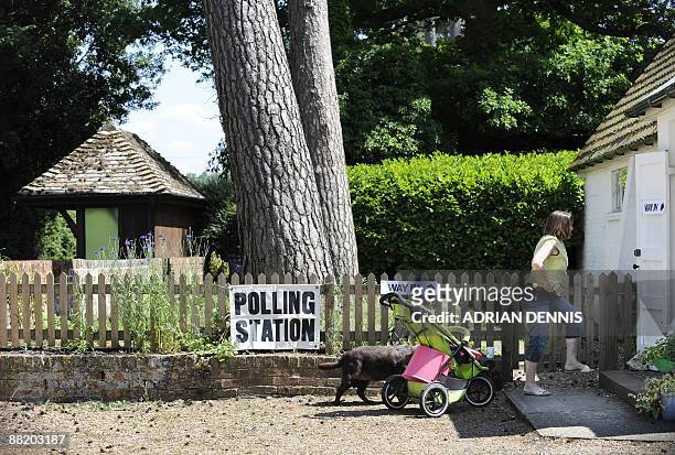 Woman arrives a polling station in Steventon, in Hampshire, an outlying village in the Basingstoke and Deane region, of southern England, on June 4,...