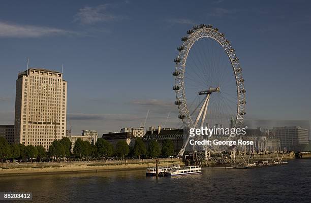 View of the London Eye, located along the Thames River at County Hall, is seen across from the Shell Oil Centre building in this 2009 London, United...