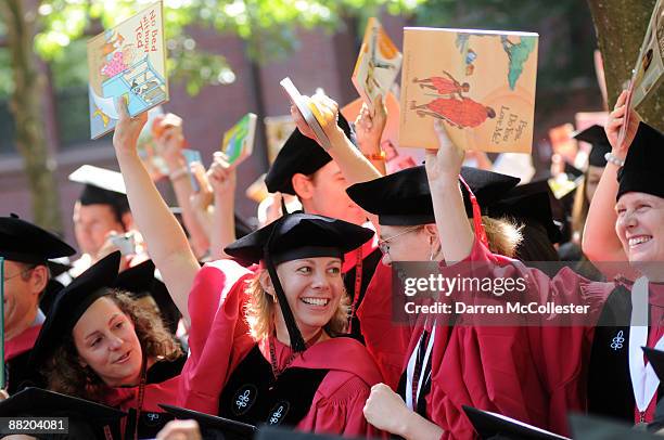 Harvard University students at the School of Education hold up books as their degree is announced during commencement ceremonies June 4, 2009 in...