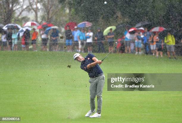 Adam Scott of Australia plays a shot as the rain falls during day one of the 2017 Australian PGA Championship at Royal Pines Resort on November 30,...