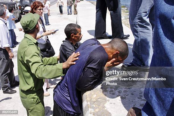 Rafter is detained by Cuban security officers after seven men failed in an attempt to leave the island at the Malecon waterfront on June 4, 2009 in...