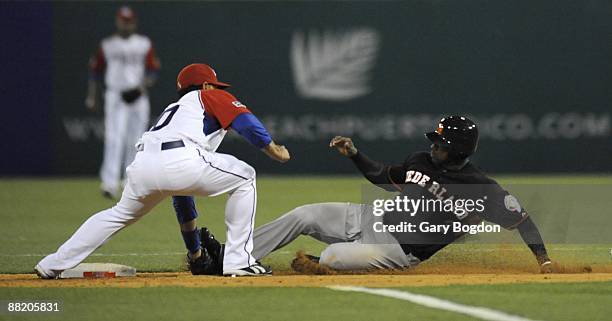 Puerto Rico's shortstop Michael Aviles tags out Netherlands Yurendell de Caster at second base during the Pool D, game four between Puerto Rico and...