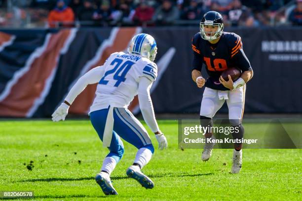 Quarterback Mitch Trubisky of the Chicago Bears carries the football toward Nevin Lawson of the Detroit Lions in the first quarter at Soldier Field...