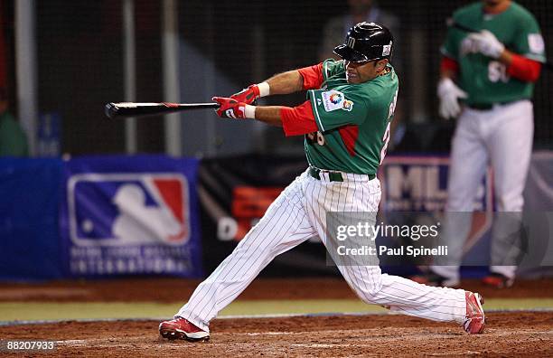 Shortstop Oscar Robles of Mexico hits a two run homer in the top of the ninth inning to give his team a 12-3 lead during the Pool B, game three...