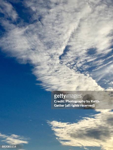 an interesting sky with white clouds in creative shapes filling up a blue sky - possible stock pictures, royalty-free photos & images