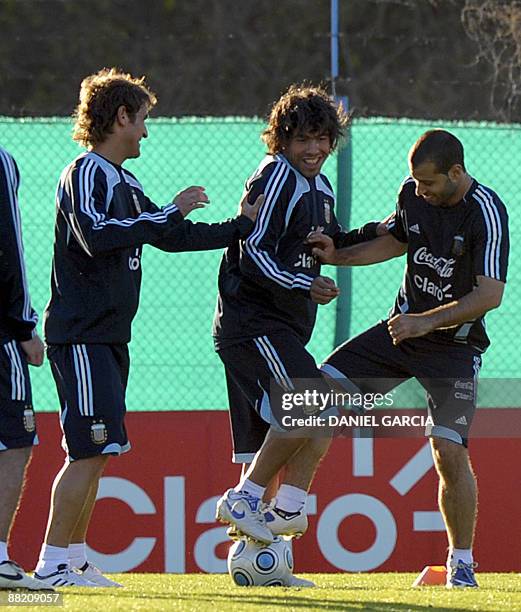 Argentina's national football players Emiliano Papa, Carlos Tevez and Javier Mascherano joke around during a training session in Ezeiza, Buenos Aires...