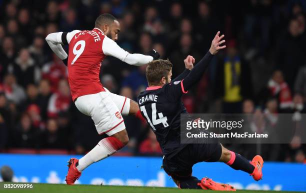 Alex Lacazette shoots past Huddersfield defender Martin Cranie to score the 1st Arsenal goal during the Premier League match between Arsenal and...