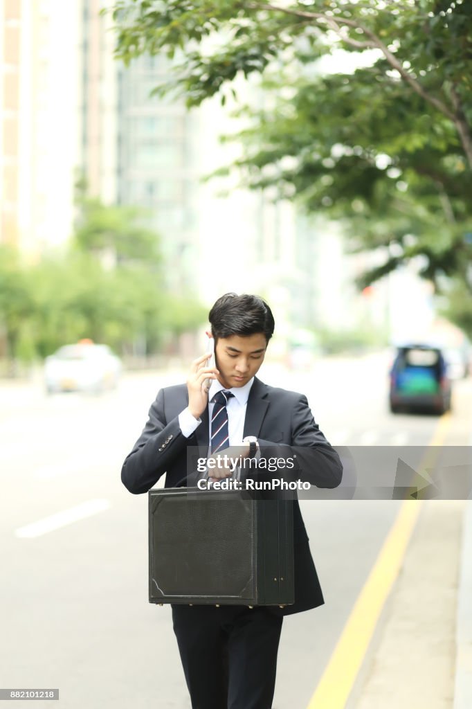 Businessman talking on the phone and checking the time