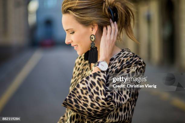 Alexandra Lapp wearing an animal printed jacket with voluminous bell sleeves by Steffen Schraut, a straight cut silk top in light gold, black skinny...