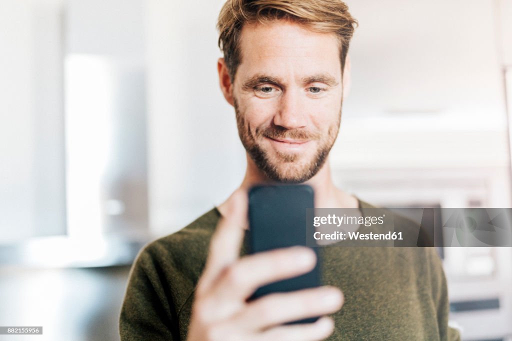 Portrait of smiling man looking at cell phone