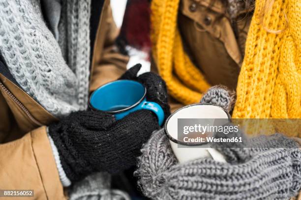 young couple wearing gloves holding cups of tea in winter, close-up - tea outdoor stock pictures, royalty-free photos & images