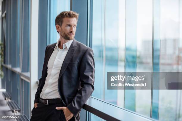 portrait of businessman looking out of the window - encuadre de tres cuartos fotografías e imágenes de stock