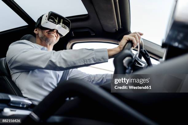 businessman wearing vr glasses driving a car - augmented reality car stockfoto's en -beelden