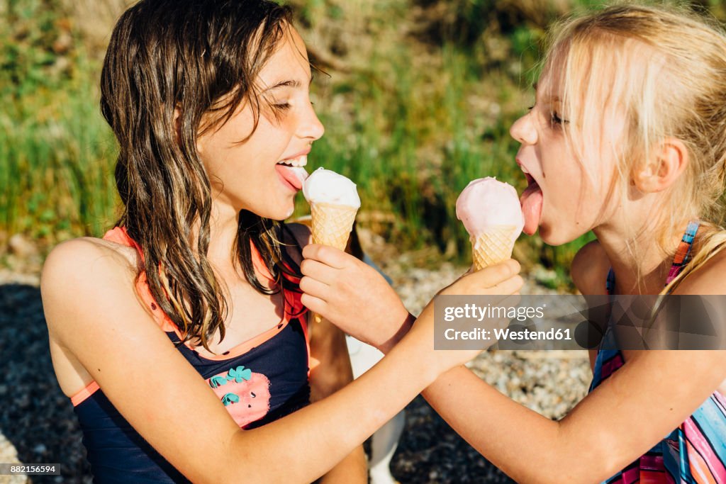 Two girls eating icecream on the beach