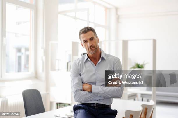 portrait of confident businessman in office - arrogance stock pictures, royalty-free photos & images