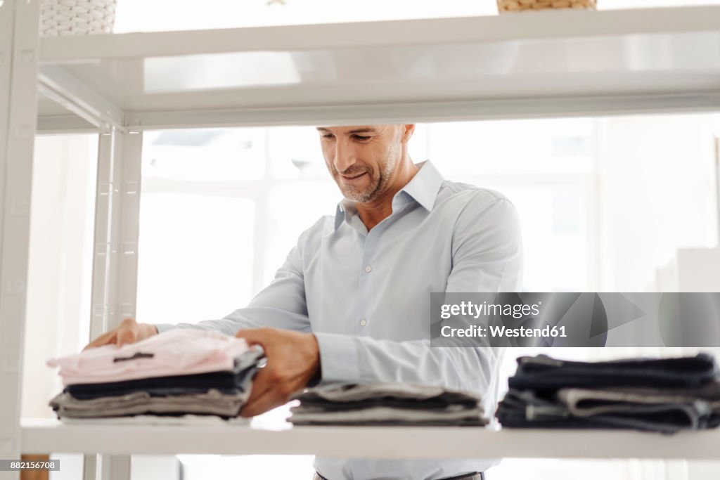 Man Intensely Sorting Businessman Sorting Clothes On Shelf High-Res Stock Photo - Getty Images