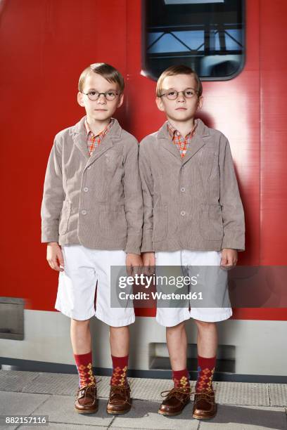 twin brothers standing in front of commuter line - twins boys stockfoto's en -beelden