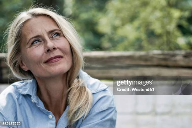 mature woman sitting on terrace, thinking - happy contemplation stock pictures, royalty-free photos & images