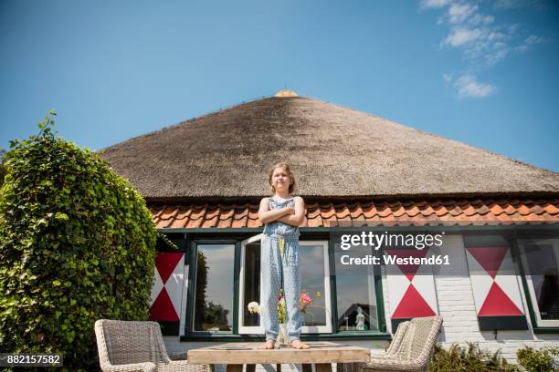 girl standing on terrace table - rieten dak stockfoto's en -beelden