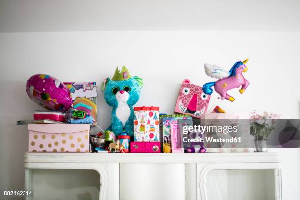 little girl's birthday presents on a cabinet - absurd birthday stock pictures, royalty-free photos & images